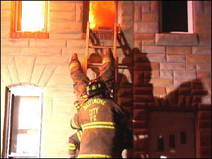 Feuerwehrmann rettet sich kopfüber über eine Leiter